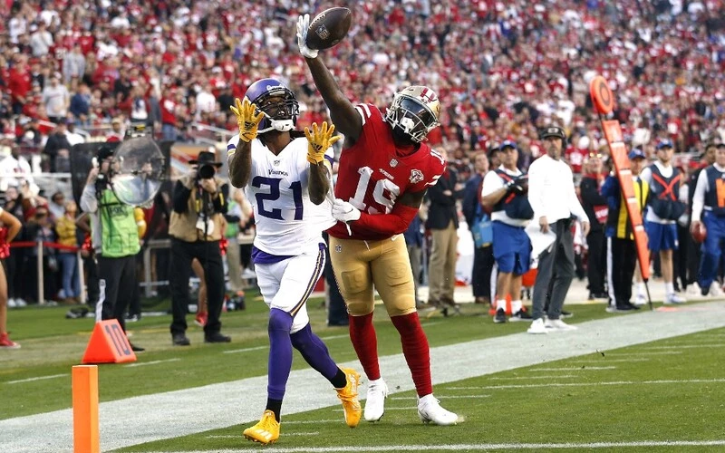 Deebo Samuel #19 of the San Francisco 49ers reaches for a pass and prevents an interception by Bashaud Breeland #21 of the Minnesota Vikings in the third quarter of the game against the San Francisco 49ers at Levi's Stadium on November 28, 2021 in Santa Clara, California. The 49ers vs Vikings Prediction is ready for analyze.