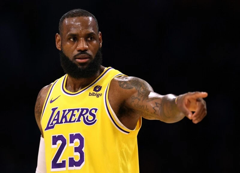 LeBron James #23 of the Los Angeles Lakers directs the defense during a 129-125 loss to the Golden State Warriors in a preseason game at Crypto.com Arena on October 13, 2023 in Los Angeles, California. The NBA Season starts with the Lakers vs Nuggets Betting Odds.