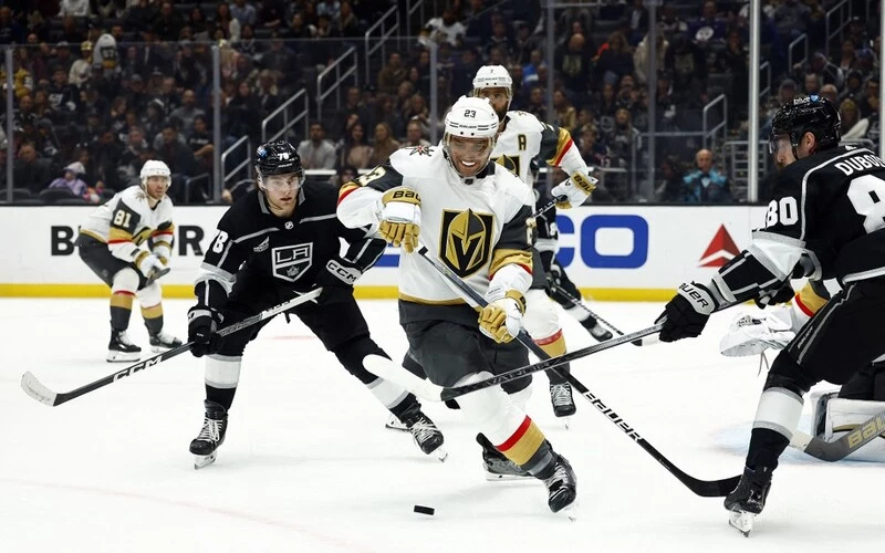 Alec Martinez #23 of the Vegas Golden Knights skates the puck against Alex Laferriere #78 and Pierre-Luc Dubois #80 of the Los Angeles Kings in the second period at Crypto.com Arena on October 28, 2023 in Los Angeles, California. The Kings vs Golden Knights Odds are set for tonight's game.