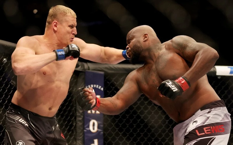 Sergei Pavlovich (L) of Russia punches Derrick Lewis in their heavyweight bout during UFC 277 at American Airlines Center on July 30, 2022 in Dallas, Texas. The Pavlovich vs Aspinall prediction is set for Saturday's UFC Main Event.