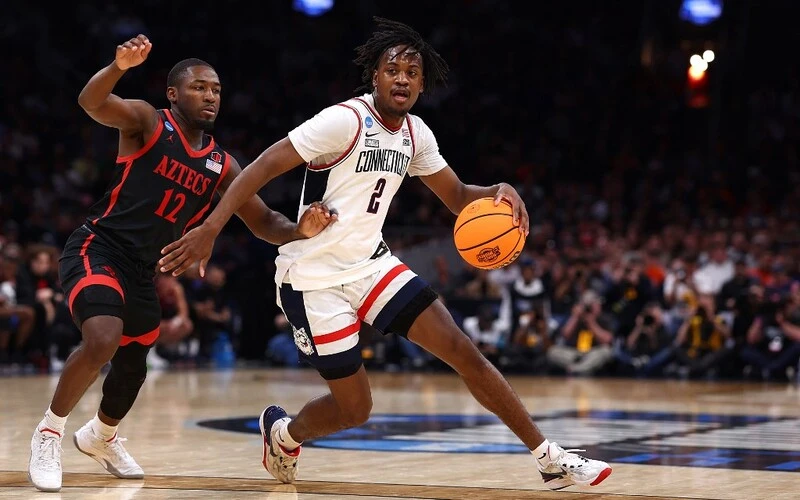 Illinois vs UConn Odds: Tristen Newton #2 of the Connecticut Huskies dribbles against Darrion Trammell #12 of the San Diego State Aztecs during the second half in the Sweet 16 round of the NCAA Men's Basketball Tournament at TD Garden on March 28, 2024 in Boston, Massachusetts. Maddie Meyer/Getty Images/AFP