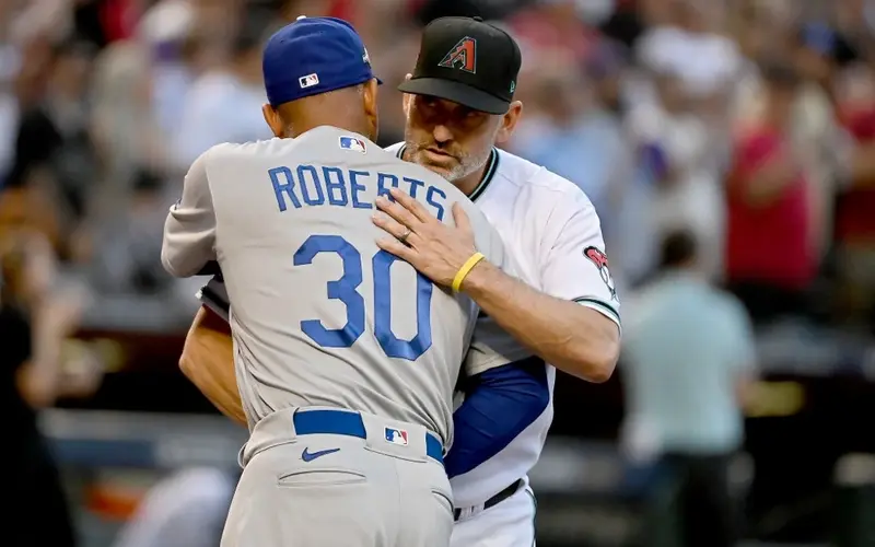 Manager Dave Roberts of the Los Angeles Dodgers and manager Torey Lovullo of the Arizona Diamondbacks meet before Game Three of the Division Series at Chase Field on October 11, 2023 in Phoenix, Arizona.