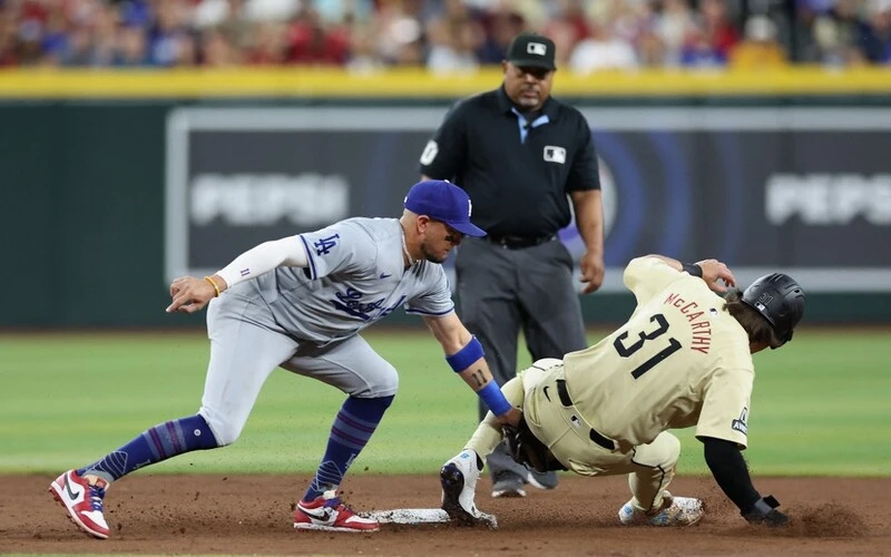 Dodgers vs Diamondbacks Prediction: Jake McCarthy #31 of the Arizona Diamondbacks safely steals second base ahead of infielder Miguel Rojas #11 of the Los Angeles Dodgers during the third inning of the MLB game at Chase Field on April 30, 2024 in Phoenix, Arizona. Christian Petersen/Getty Images/AFP